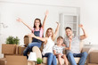 © Pixel-Shot - Happy family with belongings in their new house