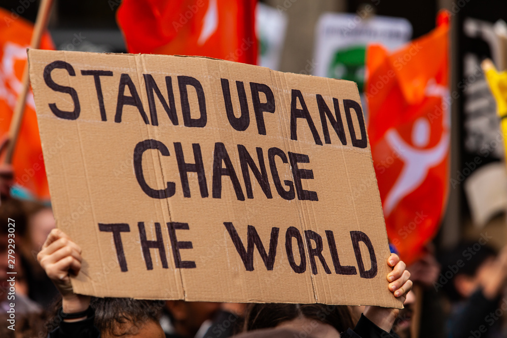 Homemade sign at environmental rally. A cardboard sign is seen close up, saying stand up and change the world, as eco-activists march for the environment on a street in Montreal, Canada - obrazy, fototapety, plakaty 