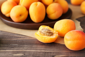 Tasty ripe apricots on wooden table, closeup