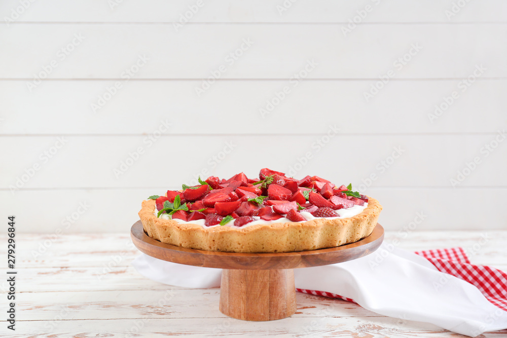 Tasty strawberry cake on white wooden table