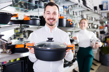 Wall Mural - Man sells different kinds of saucepan