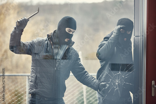 Fotografía Einbrecher mit Brecheisen schlagen Glas ein