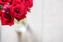 Close Up Of Red Rose Bouquet In The Vase On White Wooden Background