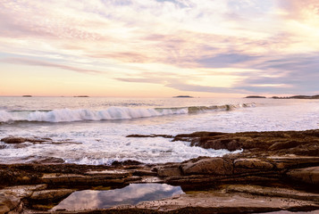 The stony coast of the Atlantic Ocean in the evening light. Deserted beautiful beach. USA. Maine.