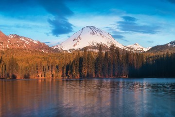 Wall Mural - manzanita lake in lassen volcanic national park with reflection of mountains and blue sky in the wat