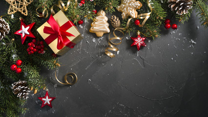Wall Mural - christmas dark black background with beautiful texture and golden gift box with red ribbon, fir bran