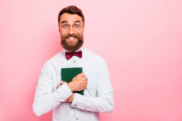 Closeup photo portrait of funny funky comic charming guy with toothy smile embracing book with green cover isolated pastel background