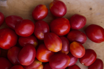 fresh colorful tomatoes in different forms collected at the farm. vegetables with defect: dark spots and cracks. a lot of tomatoes for vegetarian salads and different dishes on a wooden Board