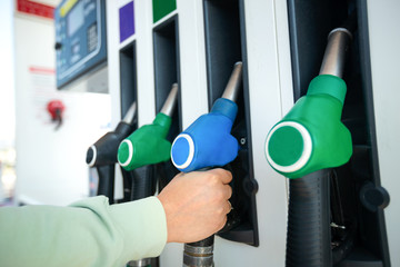 Man holding pump ready to refuel car with gasoline.