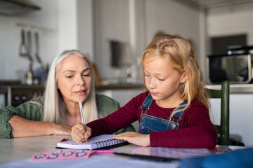 Little girl writing in homework notebook