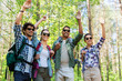 © Syda Productions - travel, tourism, hike and people concept - group of friends with backpacks waving hands in forest