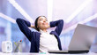 © motortion - Glad business lady relaxing on chair front of laptop in office, work break