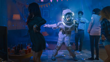 At The College House Costume Party: Fun Guy Wearing Space Suit Dances Off, Doing Robot Dance Modern Moves. With Him Beautiful Girls And Boys Dancing In Neon Lights.