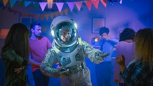 At The College House Costume Party: Fun Guy Wearing Space Suit Dances Off, Doing Robot Dance Modern Moves. With Him Beautiful Girls And Boys Dancing In Neon Lights.