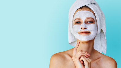 Wall Mural - beautiful young woman with facial mask on her face. skin care and treatment, spa, natural beauty and