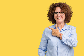 Beautiful middle ager senior businees woman wearing glasses over isolated background cheerful with a smile of face pointing with hand and finger up to the side with happy and natural expression 