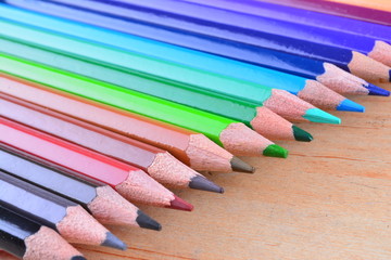 Close up stack colour pencils on wooden background