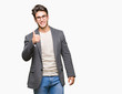 © Krakenimages.com - Young business man wearing glasses over isolated background doing happy thumbs up gesture with hand. Approving expression looking at the camera showing success.