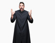 © Krakenimages.com - Young Christian priest over isolated background celebrating crazy and amazed for success with arms raised and open eyes screaming excited. Winner concept