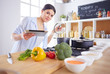 © lenets_tan - Young woman standing by the stove in the kitchen