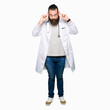© Krakenimages.com - Young blond doctor man with beard wearing medical coat Smiling pulling ears with fingers, funny gesture. Audition problem