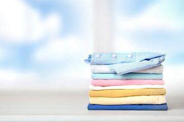 Wall Mural - Stack of colorful clothes on empty space background.