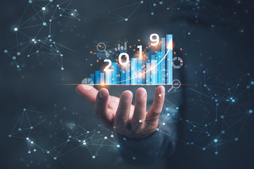Poster - 2019 New year planning business and financial concept. Businessman holding virtual screen on growth graph chart and data, business strategy, banking and investment, digital marketing and payment.