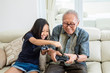 © Creativa Images - Happy girl and her grandfather play video games
