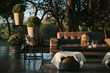 Armchairs and garden table adorned with pots, flowers and imitation leather fabrics.