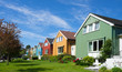 © Ingrid - Kristiansund / Norway - June 15 2019: Row of wooden houses in different colors. Lovely suburban neighborhood that fits well into Nordic nature. Bright sunny summer day emphasizes colorful scenery.