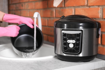 Sticker - Woman washing modern multi cooker in kitchen sink, selective focus