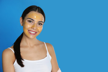 Sticker - Young woman with cleansing mask on her face against color background, space for text. Skin care