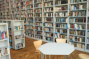 Wall Mural - Blurred view of bookshelves and table in library