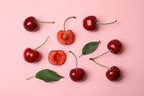 Flat lay composition with ripe sweet cherries on pink background