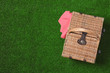 © New Africa - Closed wicker picnic basket on green grass, top view. Space for text