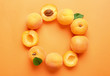 Delicious ripe sweet apricots on orange background, flat lay. Space for text
