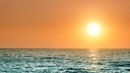 Wall Mural - sunset sky and sea panorama landscape background view from ocean beach with water sun above horizon 