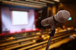 © nattanan - Microphone over the blurred business forum Meeting or Conference Training Learning Coaching Room Concept, Blurred background.