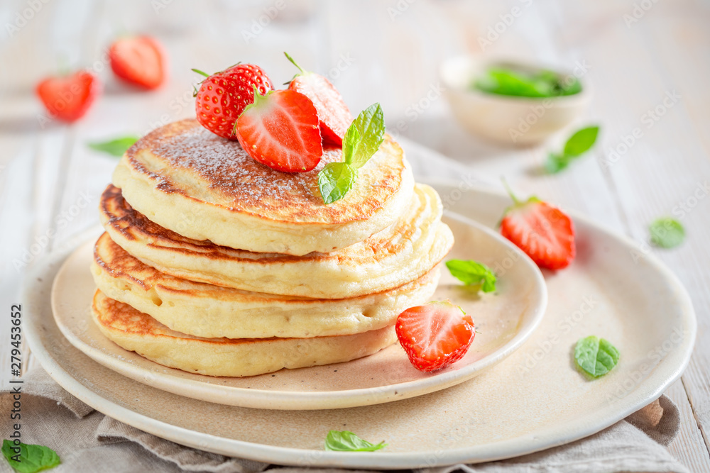Delicious american pancakes with powdered sugar and sweet strawberries - obrazy, fototapety, plakaty 