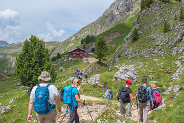 Wall Mural - hikers on their way to a mountain hut in the alps