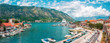 Ancient town Kotor with marina and yachts on the water, old stone houses surrounded by mountains, Montenegro. Panoramic view