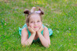 © Igor Butseroga - Cute girl lying on the green grass, outdoors, summer time, blurred background