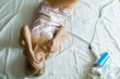 © nazariykarkhut - Portrait of a gorgeous young caucasian blonde woman in a pajama using a blow dryer while sitting on her bed in the morning
