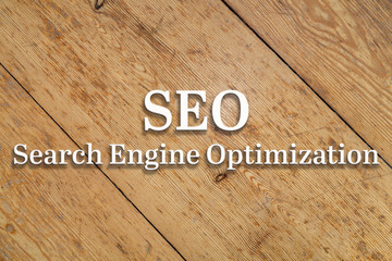 Wall Mural - `seo` white text on a wooden home background.