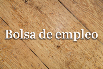 Wall Mural - `bolsa de empleo` white text on a wooden background. translation: `job market`