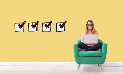 Wall Mural - Checklist with young woman using her laptop in a chair