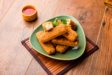 Wall Mural - Kurkuri paneer fingers or pakora/pakoda snacks also known as Crispy Cottage Cheese Bars, served with tomato ketchup as a starter. selective focus