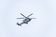 A lage white helicopter flying overhead
