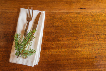 Wall Mural - Festive place setting for christmas dinner. Beautiful cutlery on the white napkin on the vintage wooden background with copy space