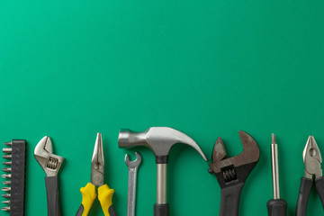 Hammer, wrench, screwdriver on a green background